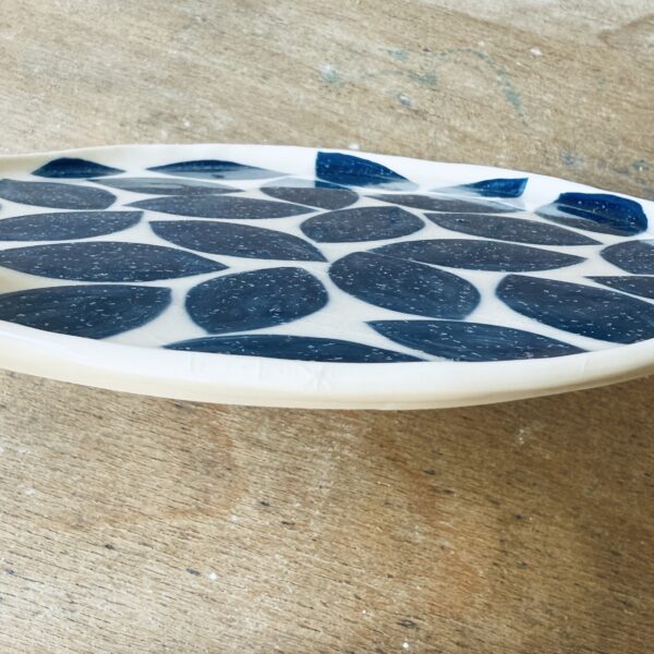 Assiette à dessert en porcelaine de la céramiste Martha Stahlkopf motif feuilles bleues, vue de côté