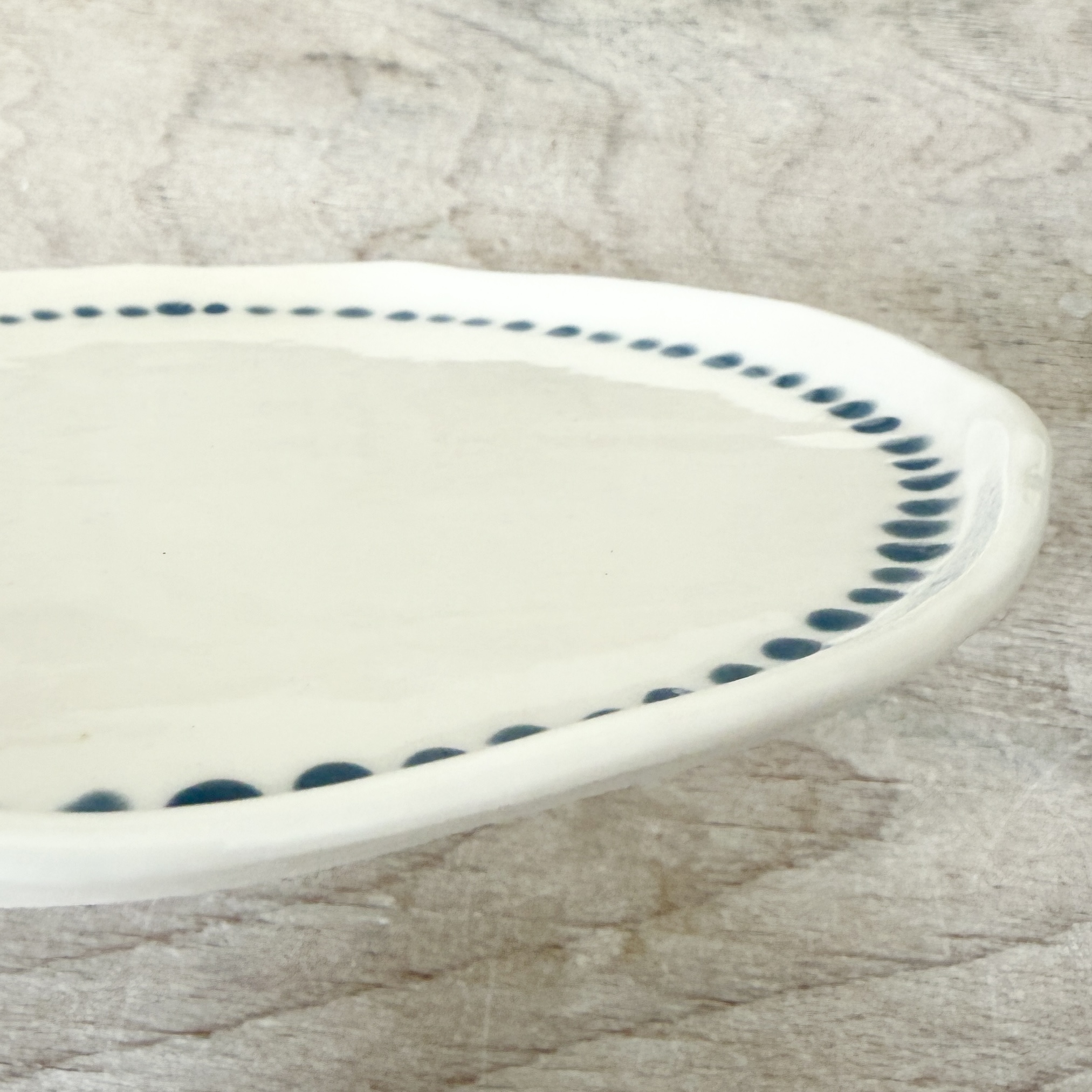 Assiette à dessert en porcelaine de la céramiste Martha Stahlkopf, motif bordure points bleu clair, côté, réalisée à Strasbourg