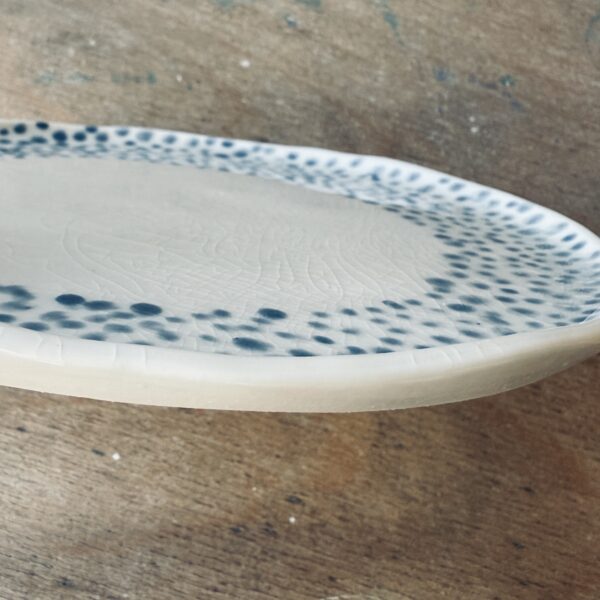 Assiette à dessert en porcelaine de la céramiste Martha Stahlkopf, motif couronne de points en bleu clair, vue de côté réalisée à Strasbourg