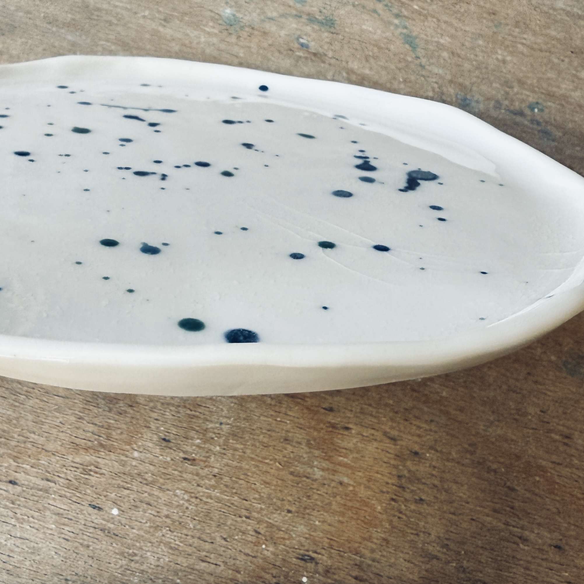 Assiette à dessert en porcelaine de la céramiste Martha Stahlkopf, motif éclaboussures en bleu et vert, vue de côté, réalisée à Strasbourg