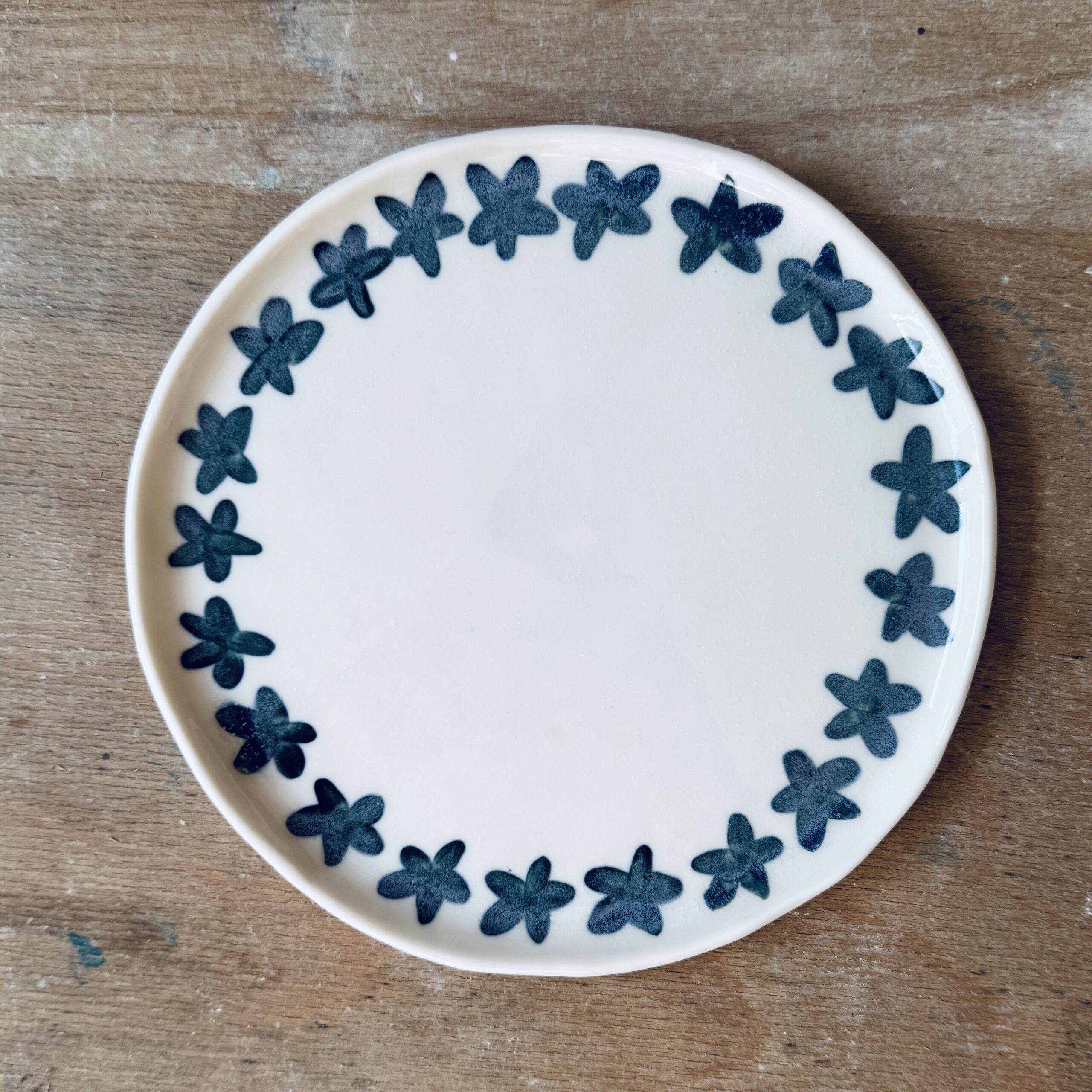 Assiette à dessert en porcelaine de la céramiste Martha Stahlkopf, motif couronne d'étoiles pétrole, réalisée à Strasbourg