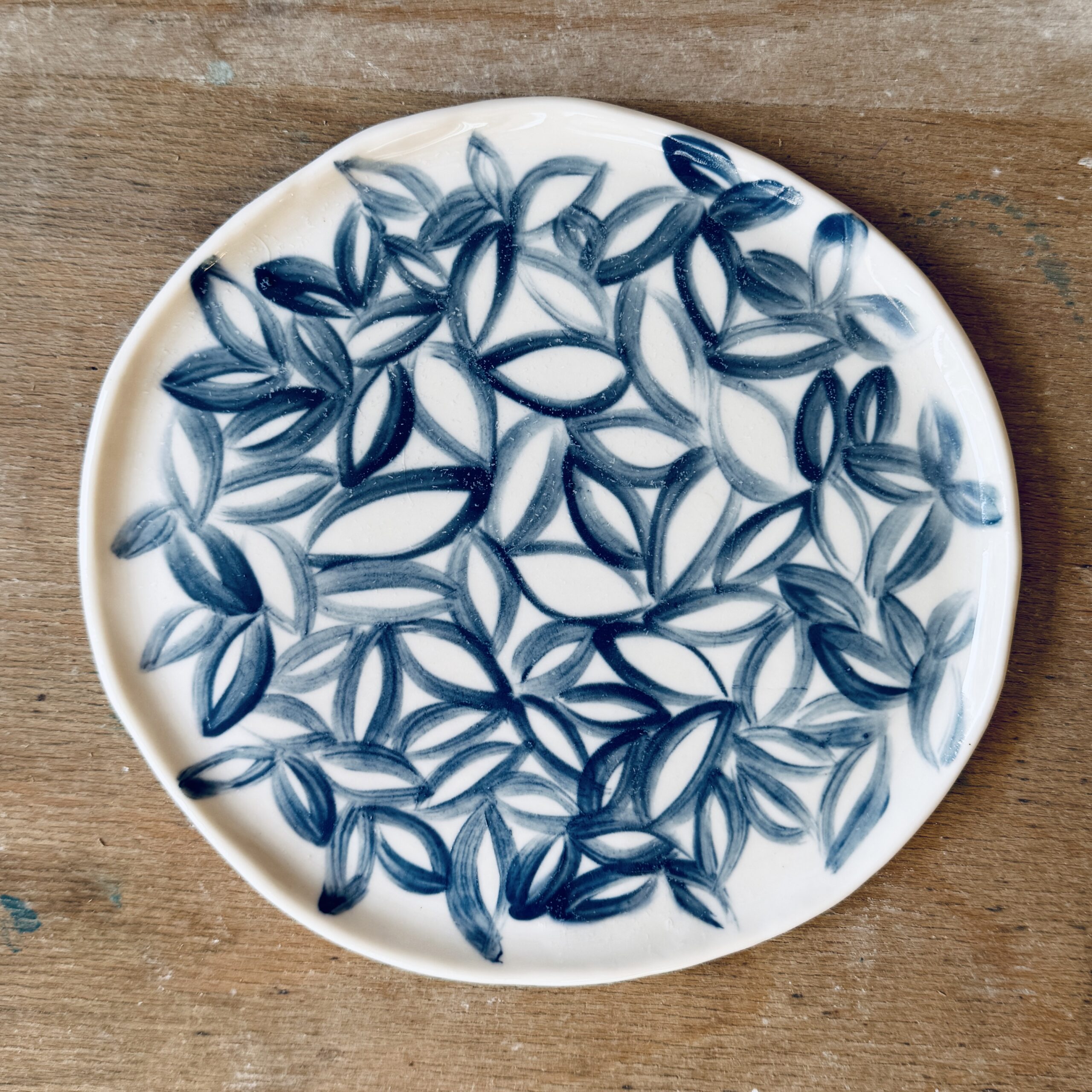Assiette à dessert en porcelaine de la céramiste Martha Stahlkopf, motif contour de feuilles bleues, réalisée à Strasbourg