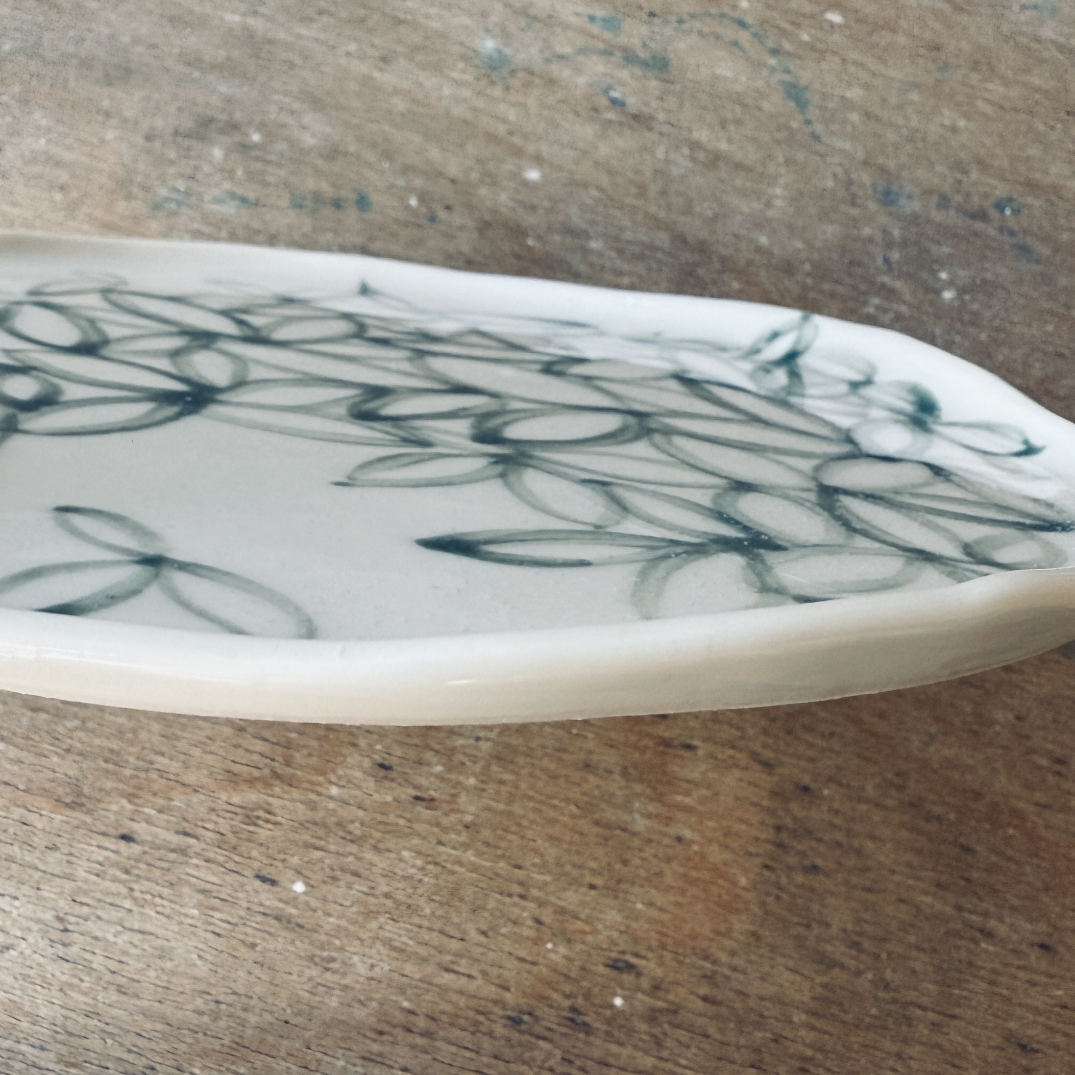 Assiette à dessert en porcelaine de la céramiste Martha Stahlkopf, motif contour de feuilles vertes, réalisée à Strasbourg