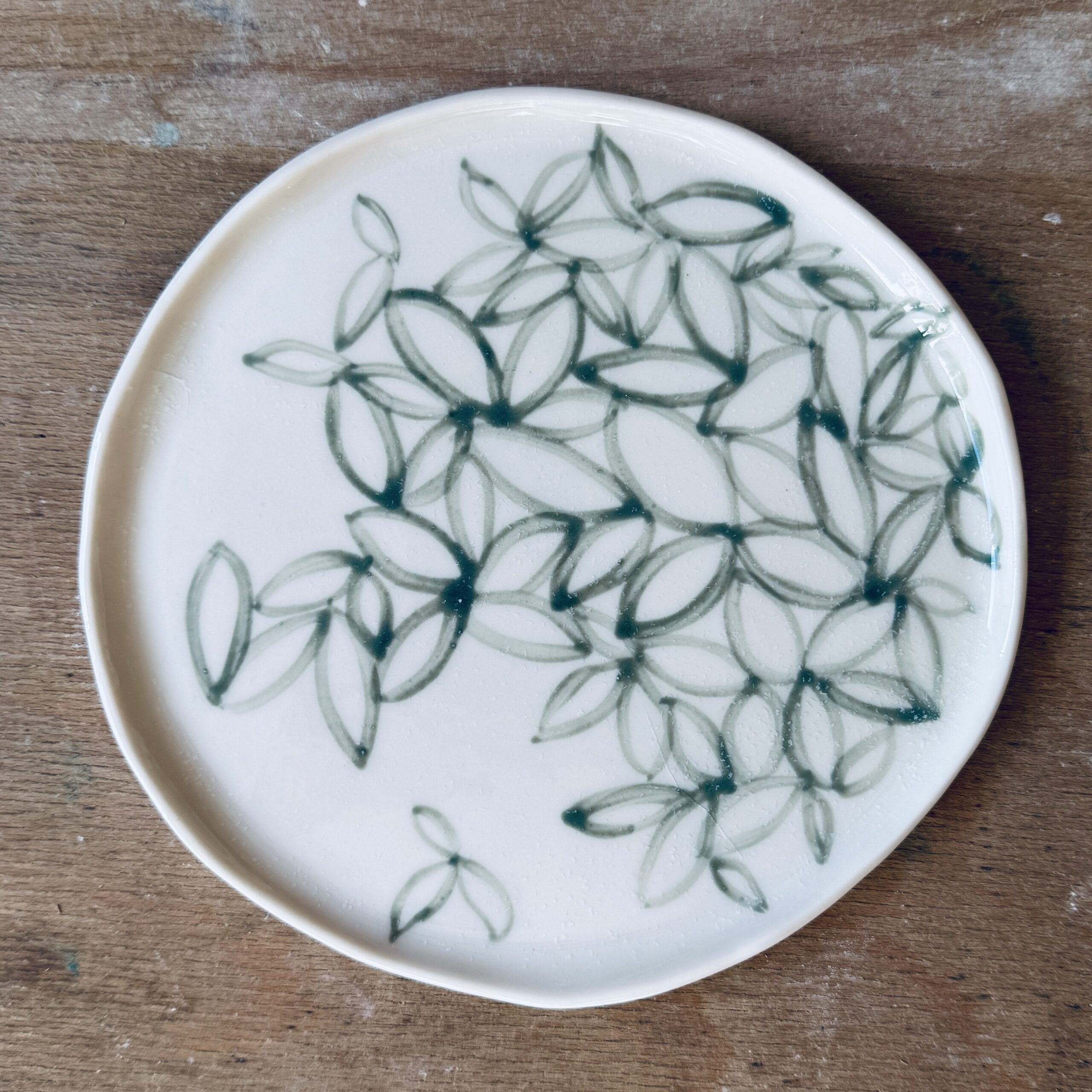 Assiette à dessert en porcelaine de la céramiste Martha Stahlkopf, motif contour de feuilles vertes, réalisée à Strasbourg