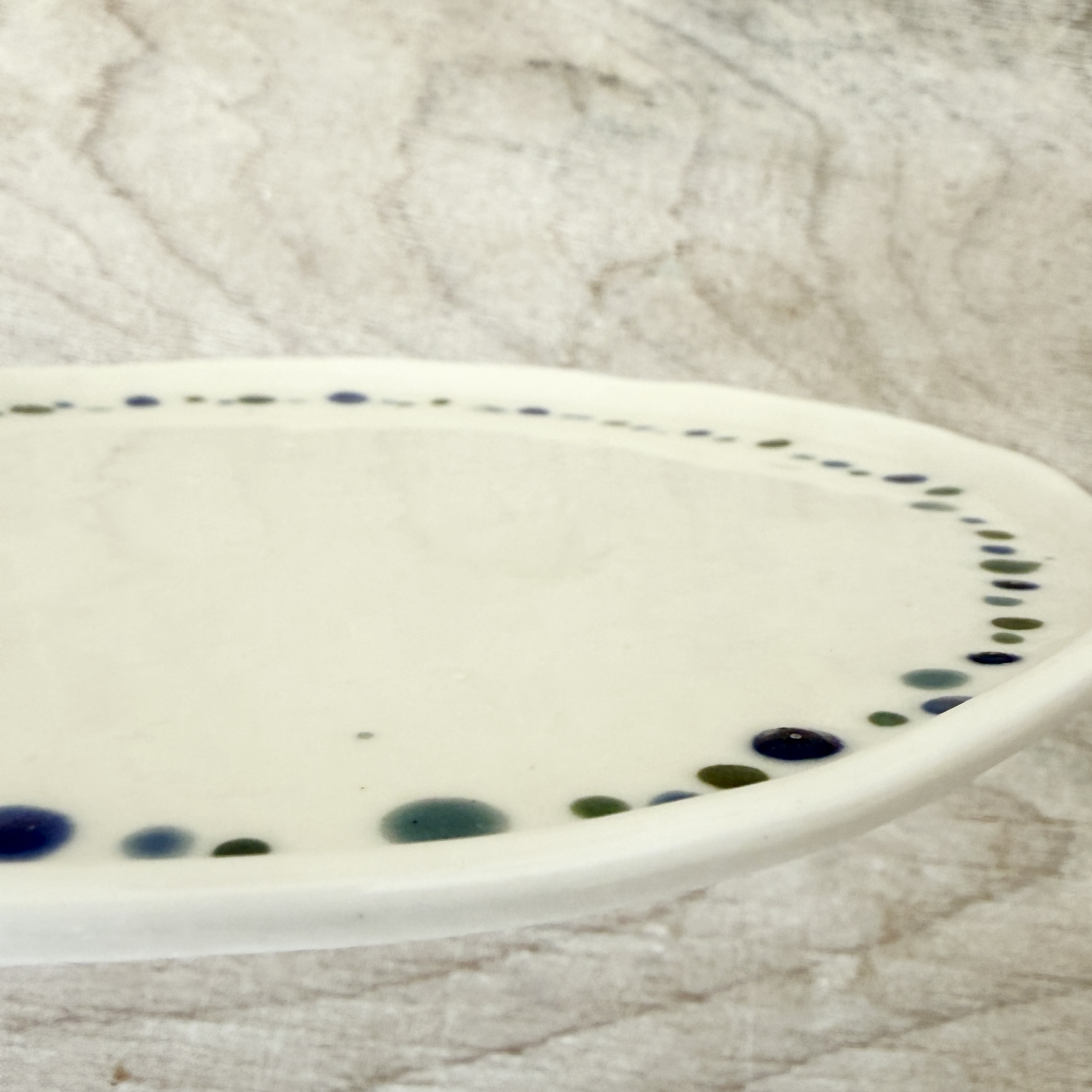 Assiette à dessert en porcelaine de la céramiste Martha Stahlkopf, motif fine couronne de points bleu et vert, côté, réalisée à Strasbourg