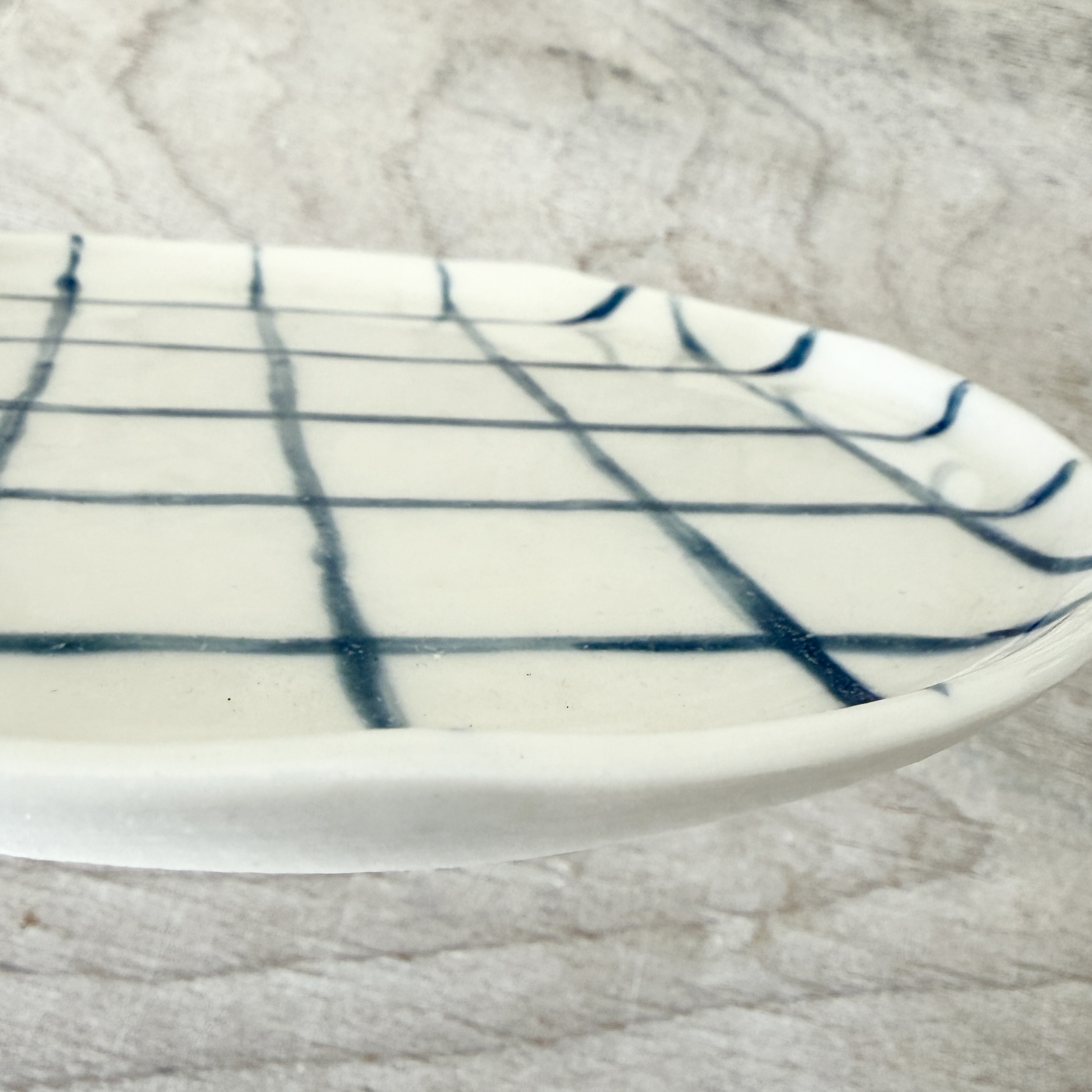Assiette à dessert en porcelaine de la céramiste Martha Stahlkopf, motif lignes carreaux en bleu, côté, réalisée à Strasbourg