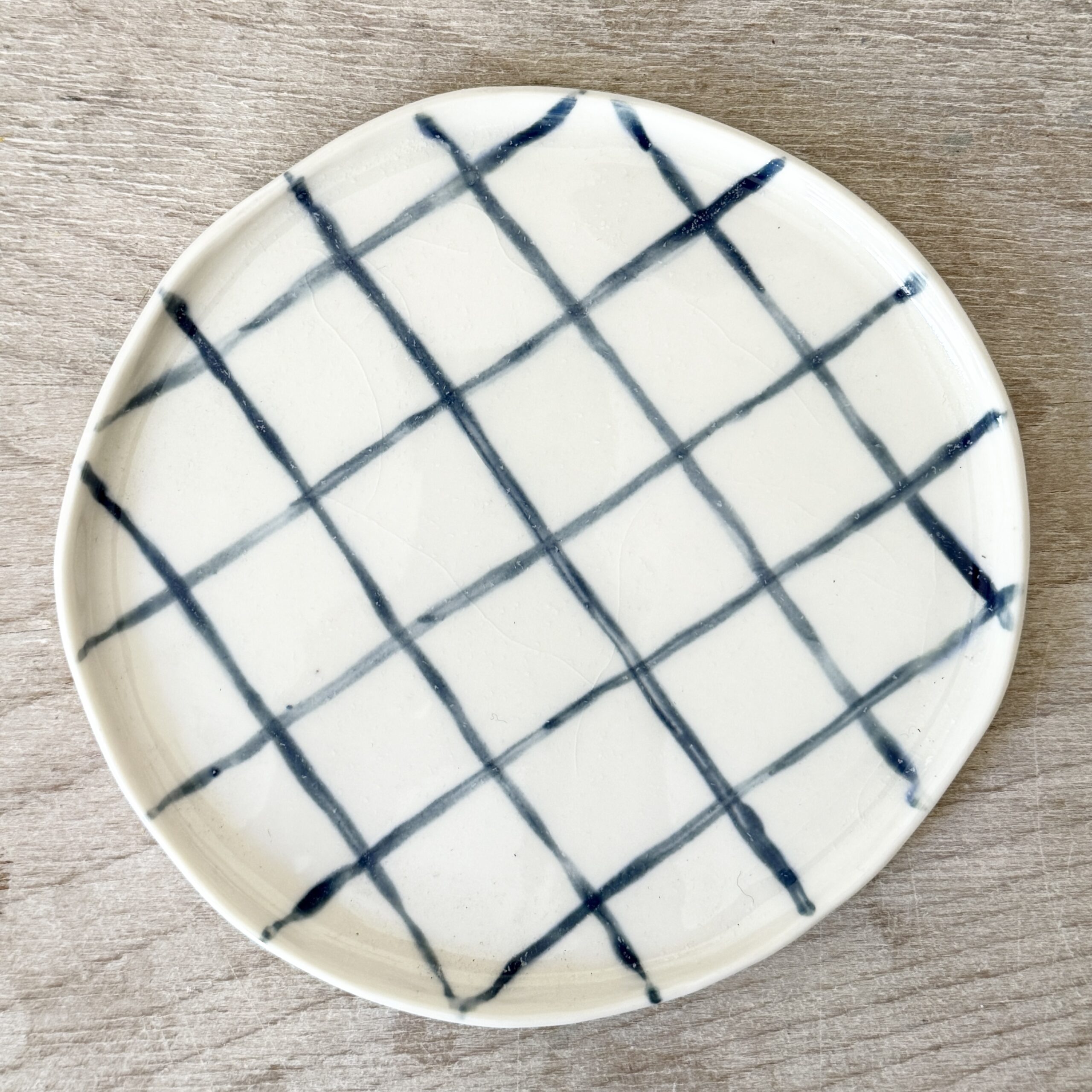 Assiette à dessert en porcelaine de la céramiste Martha Stahlkopf, motif lignes carreaux en bleu, réalisée à Strasbourg