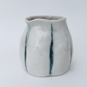 Petit pichet en porcelaine blanc avec quelques lignes verticales vertes légèrement enfoncées pour former une fleur fait par la céramiste Martha Stahlkopf dans son atelier à Strasbourg