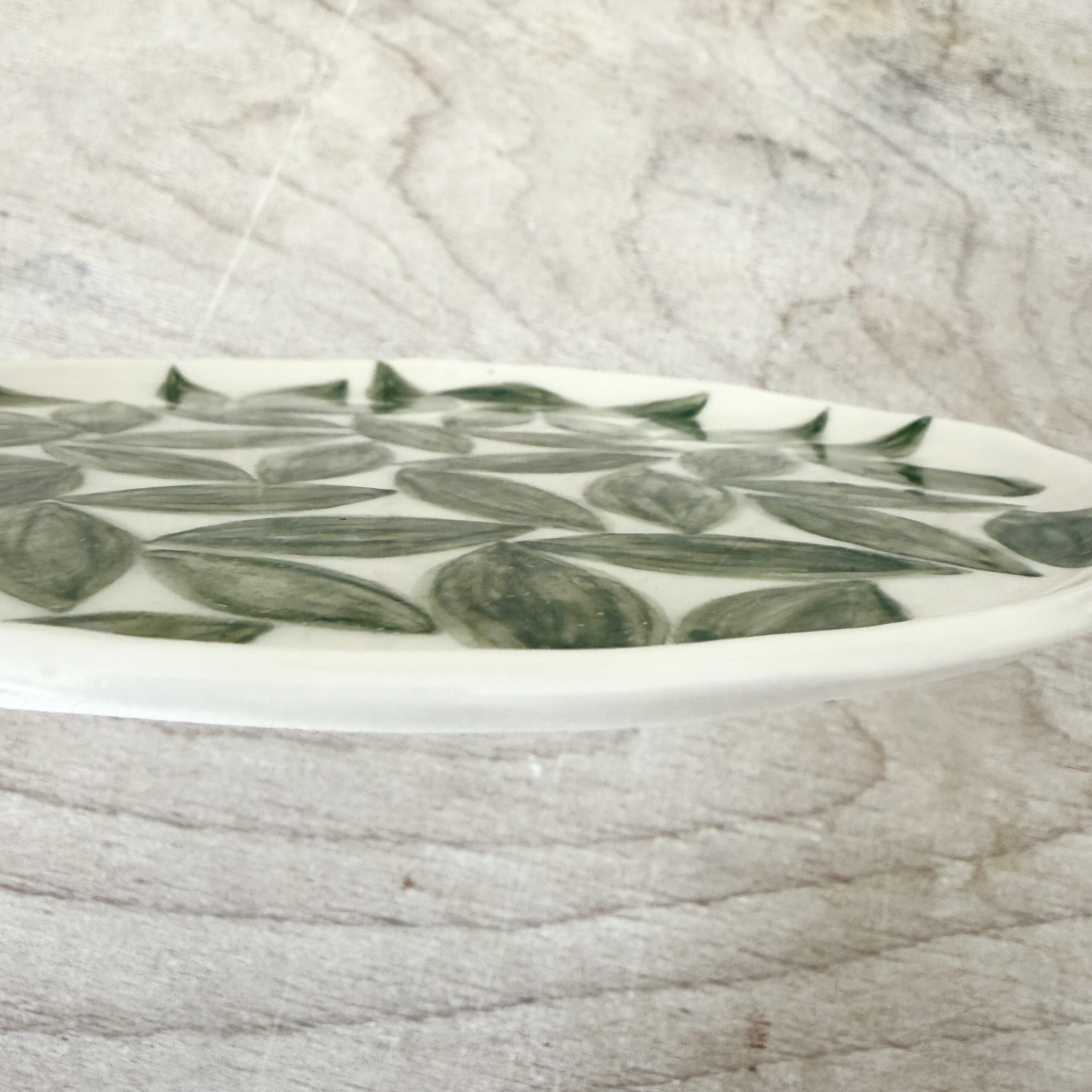 Assiette à dessert en porcelaine de la céramiste Martha Stahlkopf, motif feuilles vertes, côté, réalisée à Strasbourg